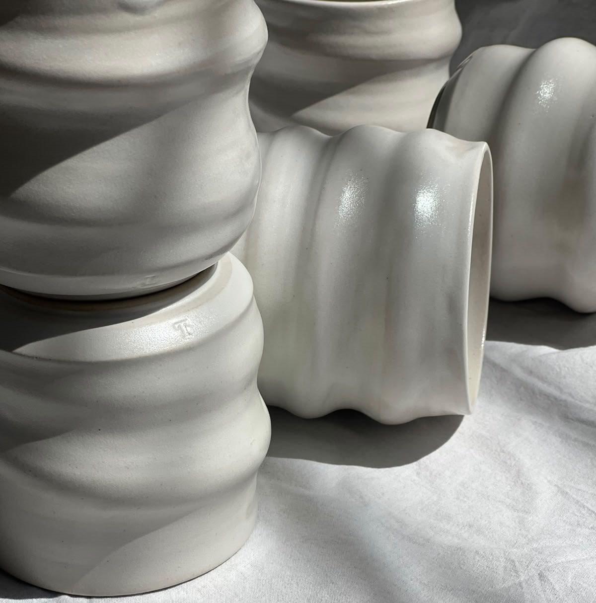 Tasses ondulées en grès blanc, posées et couchées